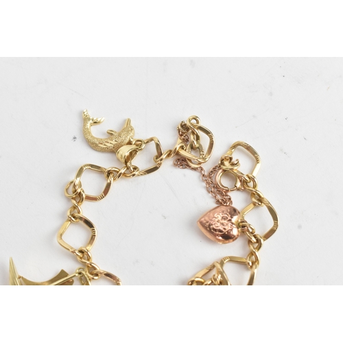 55 - A 14ct yellow gold fancy link charm bracelet, stamped 14K, having yellow gold charms, to include a p... 