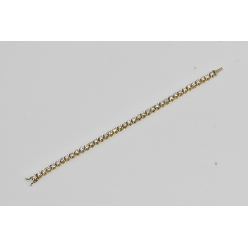 6A - A yellow gold diamond tennis bracelet with thirty-nine round brilliant cut claw set diamonds, each a... 