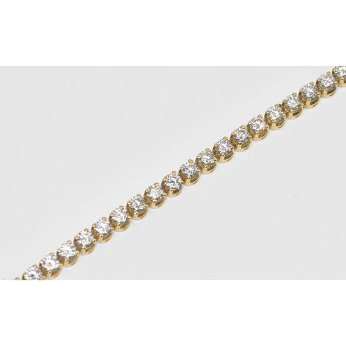 6A - A yellow gold diamond tennis bracelet with thirty-nine round brilliant cut claw set diamonds, each a... 