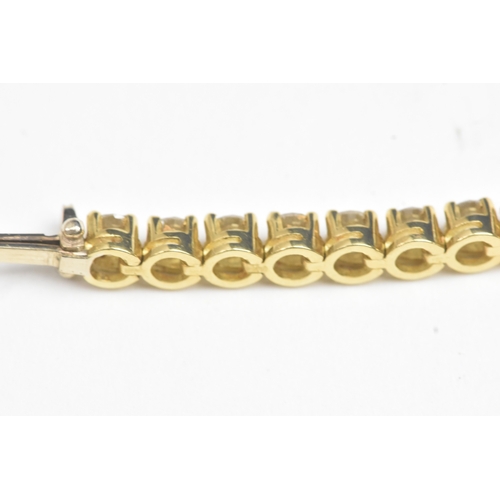 6A - A yellow gold diamond tennis bracelet with thirty-nine round brilliant cut claw set diamonds, each a... 