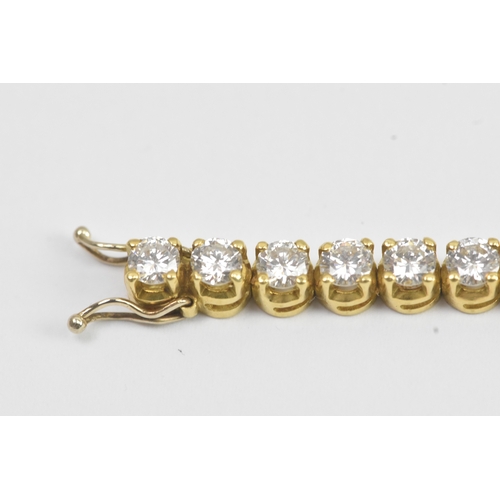6A - A yellow gold diamond tennis bracelet with thirty-nine round brilliant cut claw set diamonds, each a... 
