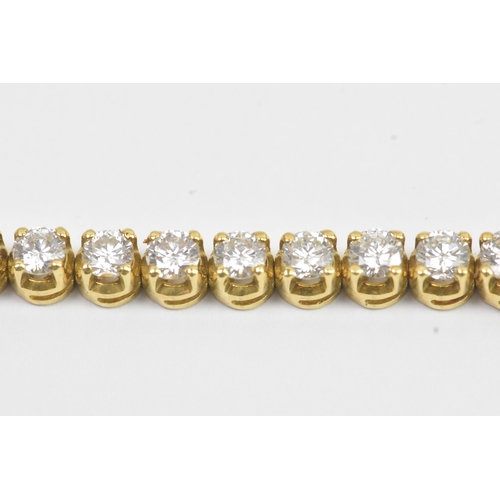 6A - A yellow gold diamond tennis bracelet with thirty-nine round brilliant cut claw set diamonds, each a... 