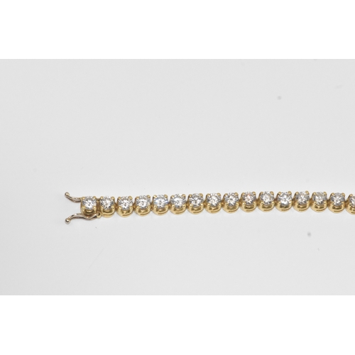 6A - A yellow gold diamond tennis bracelet with thirty-nine round brilliant cut claw set diamonds, each a... 