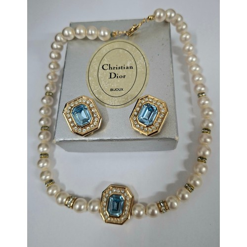 Christian Dior- A late 20th Century simulated pearl necklace with intermittent gold tone and white crystal accents having an octagonal gold tone pendant with central faceted pale blue crystal surrounded by small white crystals together with matching clip on earrings, branded boxes and slip cases. Location:
If there is no condition report, please request