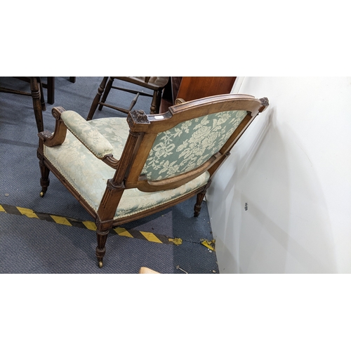 11 - An early 20th century French armchair having floral upholstery, carved scrolled arms and on casters
... 
