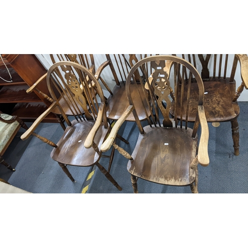 12 - A set of four mid-20th century beech Windsor wheel back dining chairs and a similar elm seated carve... 