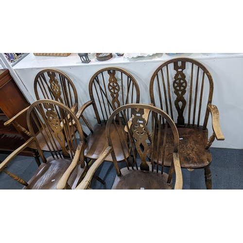 12 - A set of four mid-20th century beech Windsor wheel back dining chairs and a similar elm seated carve... 