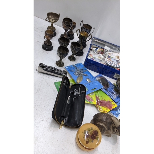 25 - A mixed lot to include silver plated trophies, Poole pottery ornaments, horn handled crumb scoop, lo... 