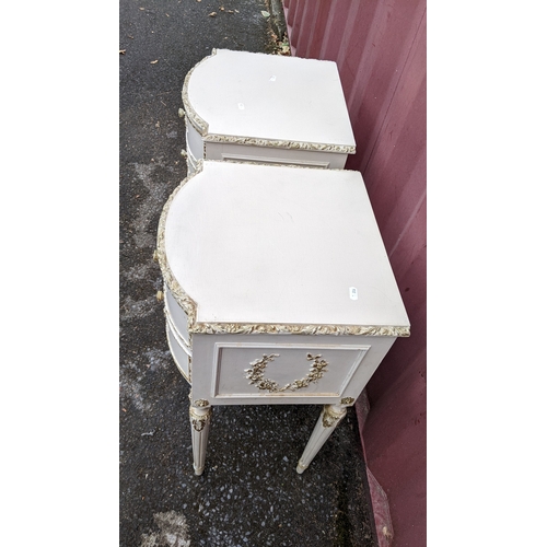 32 - A pair of mid-20th century French cream painted bow-fronted bedside tables, 70.5H x 39.5W
Location: ... 