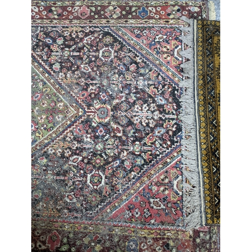 A group of three rugs to include a hand knotted Iranian rug with ...