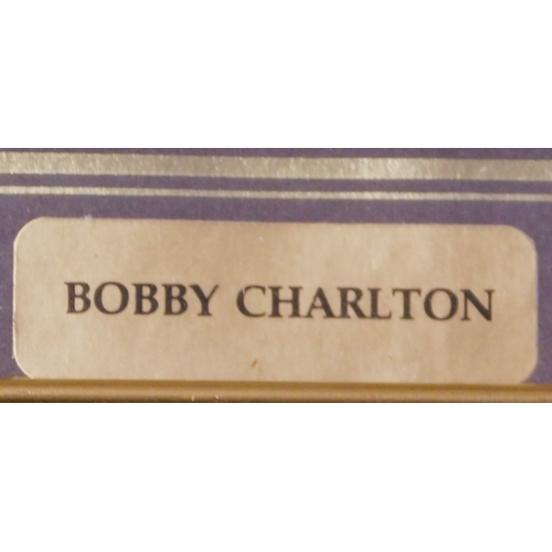 265 - A framed limited edition painting of Bobby Charlton plus a photo (possibly a press photo) of Charlto... 