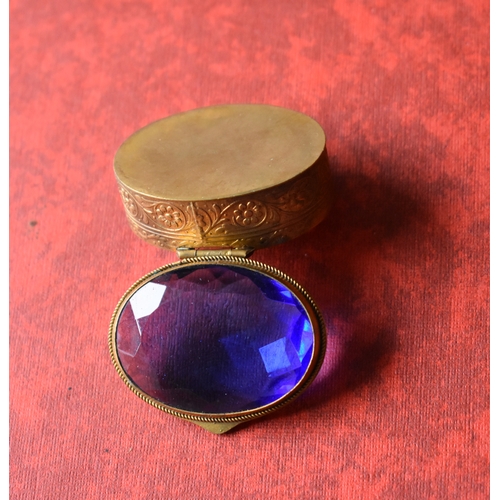 157 - Decorative gilt and blue glass oval trinket box. Good condition. Measures approx. 43mm x 33mm x 18mm