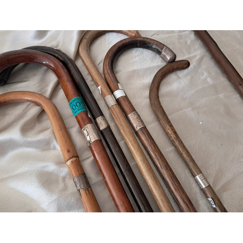 52 - Collection of 8  Walking Sticks - 5 with Silver Banding in an Embossed Brass Stick Stand