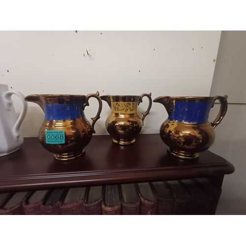 68 - Three Lustreware Milk Jugs and a Set of 3 Graduated Porcelain Dresser Jugs