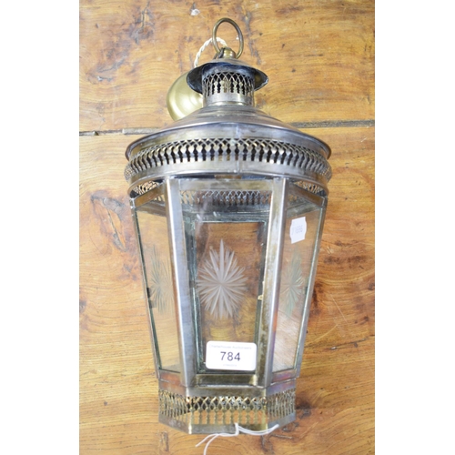 784 - A steel hanging lantern, of hexagonal tapering form, with pierced decoration and cut glass panels, 2... 