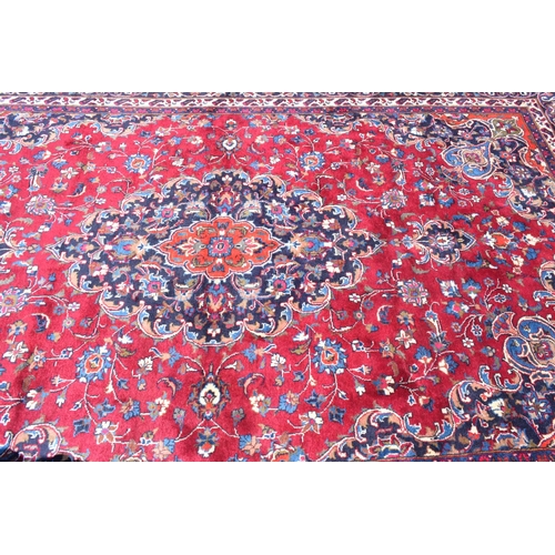 1033 - An Eastern rug, decorated swirling floral motifs on a purple ground, within a multi border, 207 x 30... 