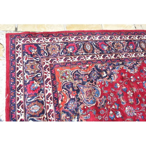 1033 - An Eastern rug, decorated swirling floral motifs on a purple ground, within a multi border, 207 x 30... 