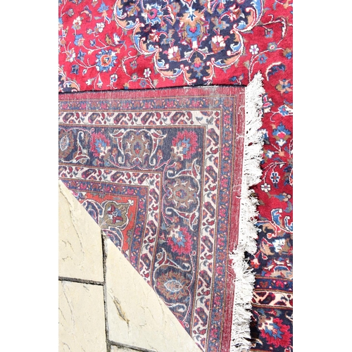 1033 - An Eastern rug, decorated swirling floral motifs on a purple ground, within a multi border, 207 x 30... 