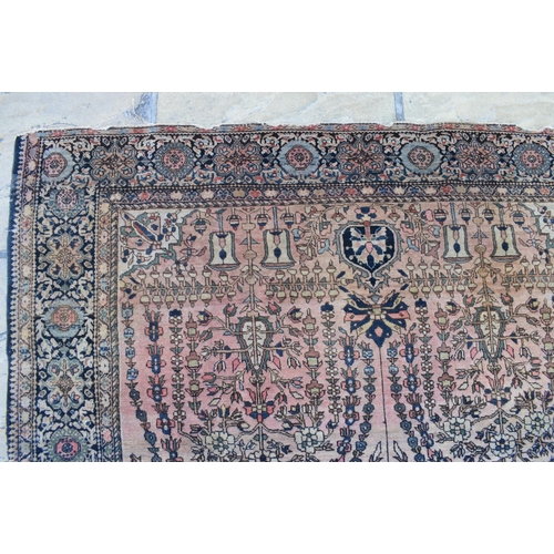 1036 - An Eastern rug, decorated floral and other motifs on a light red ground, within a multi border, 190 ... 