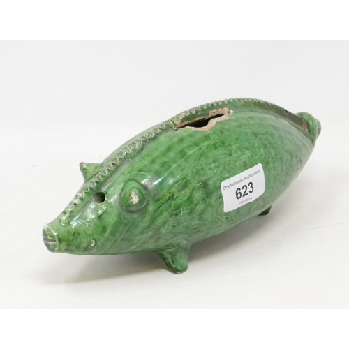 623 - An earthenware money bank, in the form of a pig, with a green glaze, 25 cm long