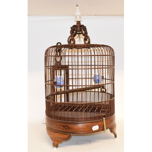 687 - A bird cage, fitted two porcelain feeders, 67.5 cm high, two table lamps, an embroidered panel, cric... 