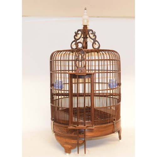 687 - A bird cage, fitted two porcelain feeders, 67.5 cm high, two table lamps, an embroidered panel, cric... 