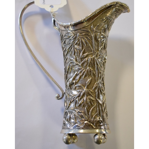 763 - An early 20th century Chinese export silver coloured metal cream jug, initialled, embossed bamboo an... 