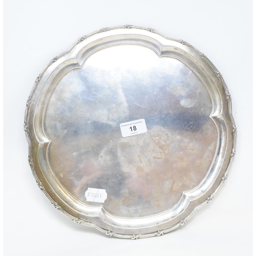 18 - A silver salver, of shaped circular form, with a bead and scroll border, Birmingham 1931, approx. 24... 