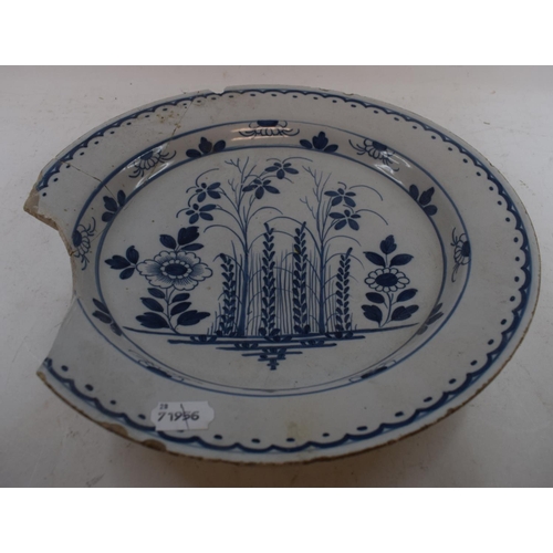 569 - A Delft blue and white pottery charger, decorated flowers, chipped, 35 cm diameter, and a blue and w... 