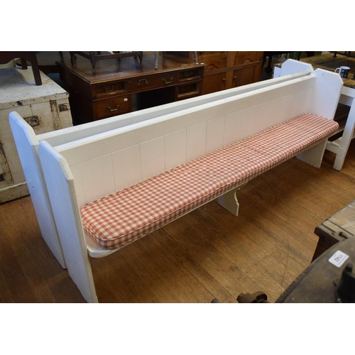 1144 - A near pair of white painted church pews, the longest 236 cm