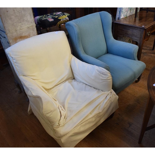 1154 - A late 19th/early 20th century wing back armchair, on turned front legs, with light blue upholstery,... 