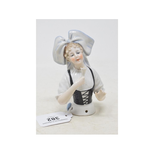 382 - A porcelain half doll, lady wearing Alsace regional costume, holding a wine glass, impressed no. 441... 