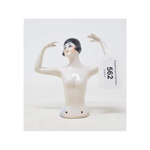 562 - A porcelain half doll, nude lady with black bobbed hair, arms up over her head, 10 cm high