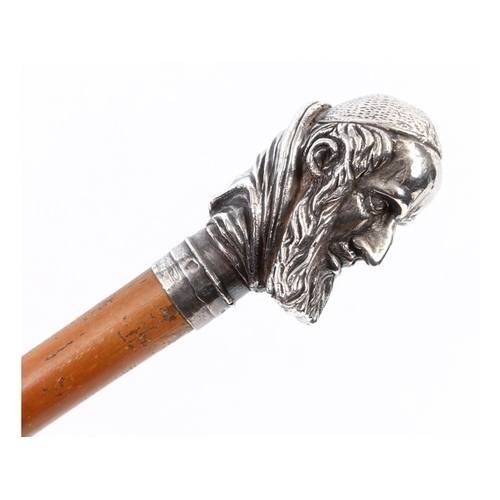 666 - A walking cane, having a silver coloured metal handle in the form of the head of a religious figure,... 