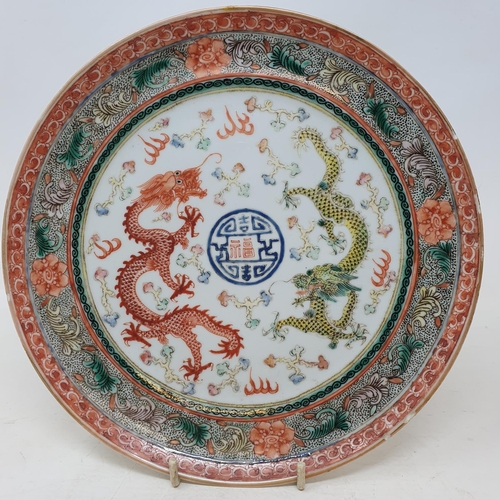 261 - A pair of Chinese porcelain plates, decorated dragons chasing flaming pearls, flowers and foliage, a... 