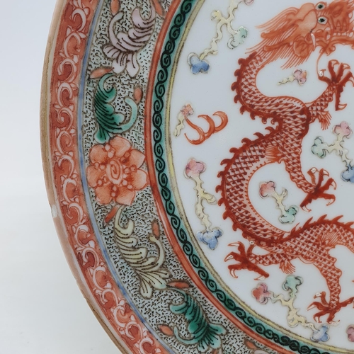 261 - A pair of Chinese porcelain plates, decorated dragons chasing flaming pearls, flowers and foliage, a... 