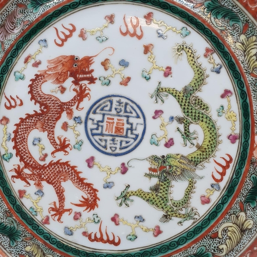 261 - A pair of Chinese porcelain plates, decorated dragons chasing flaming pearls, flowers and foliage, a... 