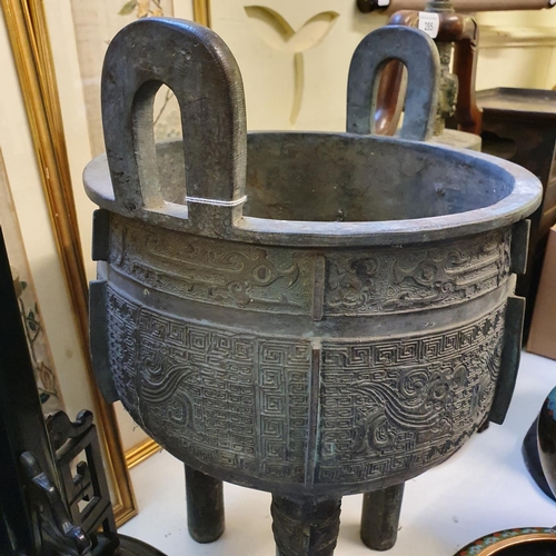 284 - A Chinese bronze censer, with twin handles, decorated clouds and other motifs, on three legs, 27 cm ... 