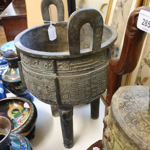 284 - A Chinese bronze censer, with twin handles, decorated clouds and other motifs, on three legs, 27 cm ... 