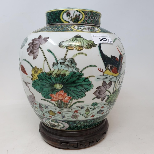 300 - A pair of Chinese famille verte ginger jars and covers, decorated birds, flowers and foliage, 21.5 c... 