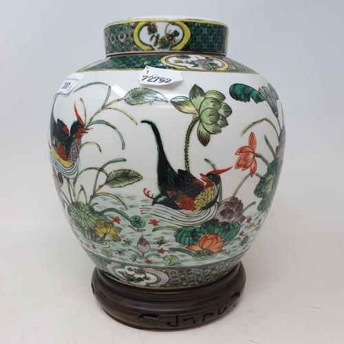 300 - A pair of Chinese famille verte ginger jars and covers, decorated birds, flowers and foliage, 21.5 c... 
