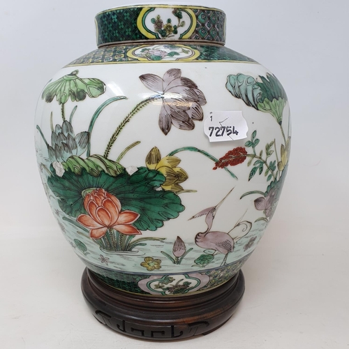 300 - A pair of Chinese famille verte ginger jars and covers, decorated birds, flowers and foliage, 21.5 c... 