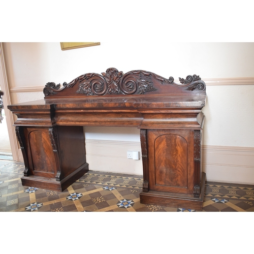 15 - An early Victorian mahogany pedestal sideboard, the back carved scrolling acanthus leaves and grapes... 