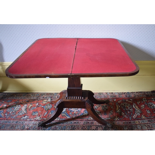 157 - A Regency mahogany D shaped card table, on a tapering column with four reeded downswept legs, 91 cm ... 