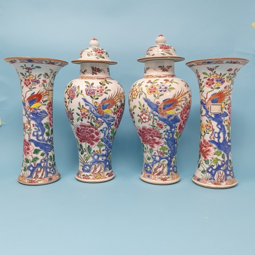 185 - A Chinese famille rose garniture of four vases, decorated flowering shrubs and exotic birds, compris... 