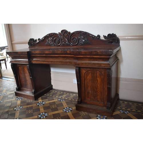 15 - An early Victorian mahogany pedestal sideboard, the back carved scrolling acanthus leaves and grapes... 