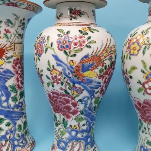 185 - A Chinese famille rose garniture of four vases, decorated flowering shrubs and exotic birds, compris... 