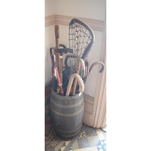 22 - A coopered oak barrel stick stand, 56 cm high, three shooting sticks, a lacrosse stick and other sti... 