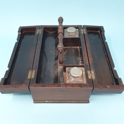 237 - A late Regency rosewood desk box, with a carrying handle, and two lid sections opening to reveal the... 