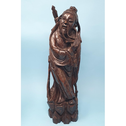 241 - A Chinese carved wood figure, of a warrior, with silver coloured metal inlaid decoration, 38 cm high... 